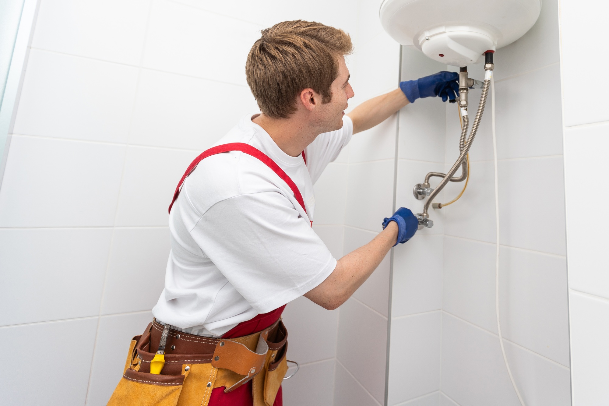 Professional plumber checking a boiler and pipes, boiler service concept.